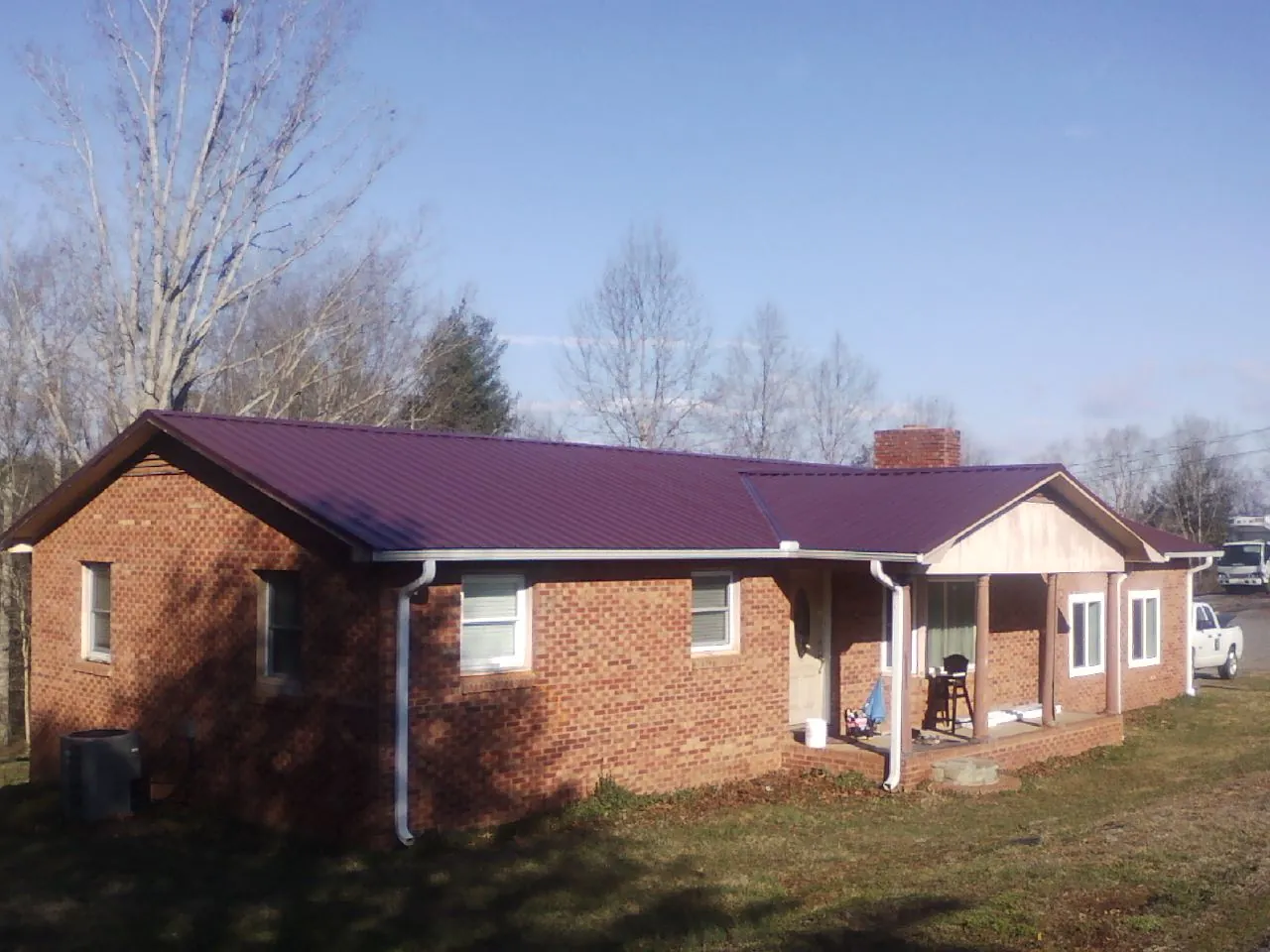 Burgundy metal roof on a brick ranch home with a new addition in Monteview