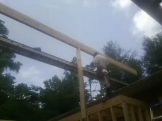Carpenter setting a ridge beam over a new addition frame — Ice Dam Removal by Roofing Brothers in Monteview